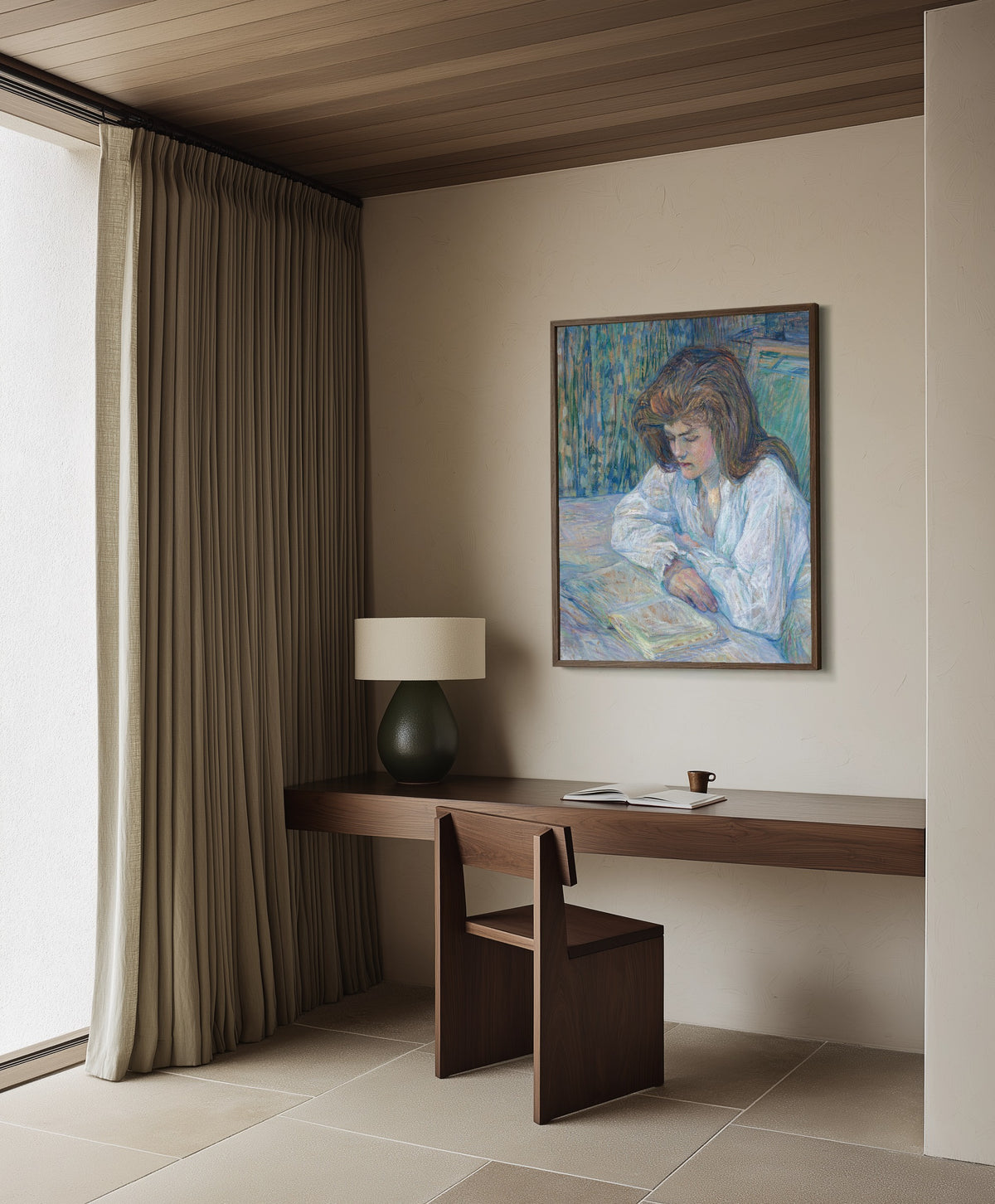 Framed art print of La Liseuse by Henri de Toulouse-Lautrec, in a dark wood frame on a plaster wall above a walnut desk