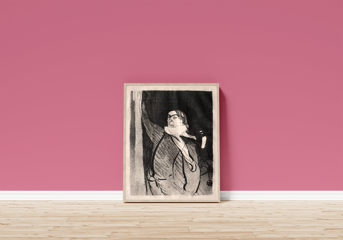 Framed art print of Le Café-Concert: Aristide Bruant by Henri de Toulouse-Lautrec, in a light wood frame leaning on a pink wall above a wooden floor