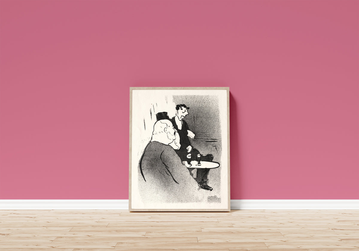 Framed art print of Le Café-Concert: Ducarre aux Ambassadeurs by Henri de Toulouse-Lautrec, in a light wood frame leaning on a pink wall above a wooden floor