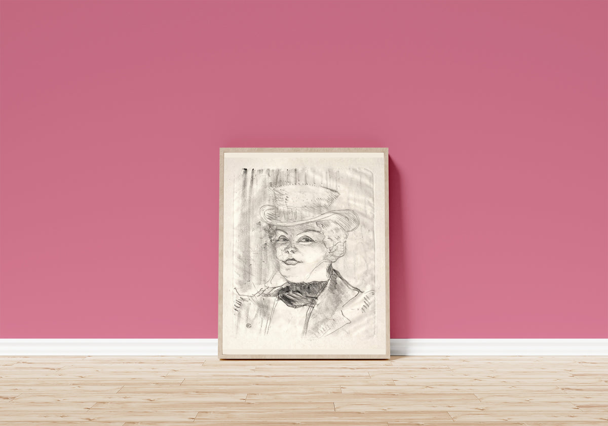 Framed art print of Madame Réjane by Henri de Toulouse-Lautrec, in a light wood frame leaning on a pink wall above a wooden floor