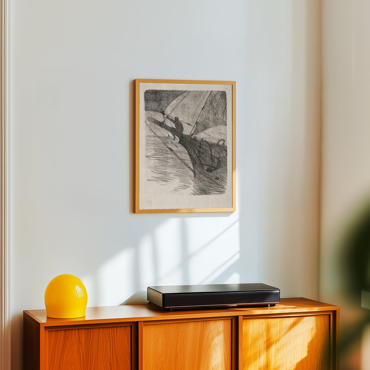 Framed art print of Oceano Nox by Henri de Toulouse-Lautrec, in a light wood frame on a white wall above an orange sideboard