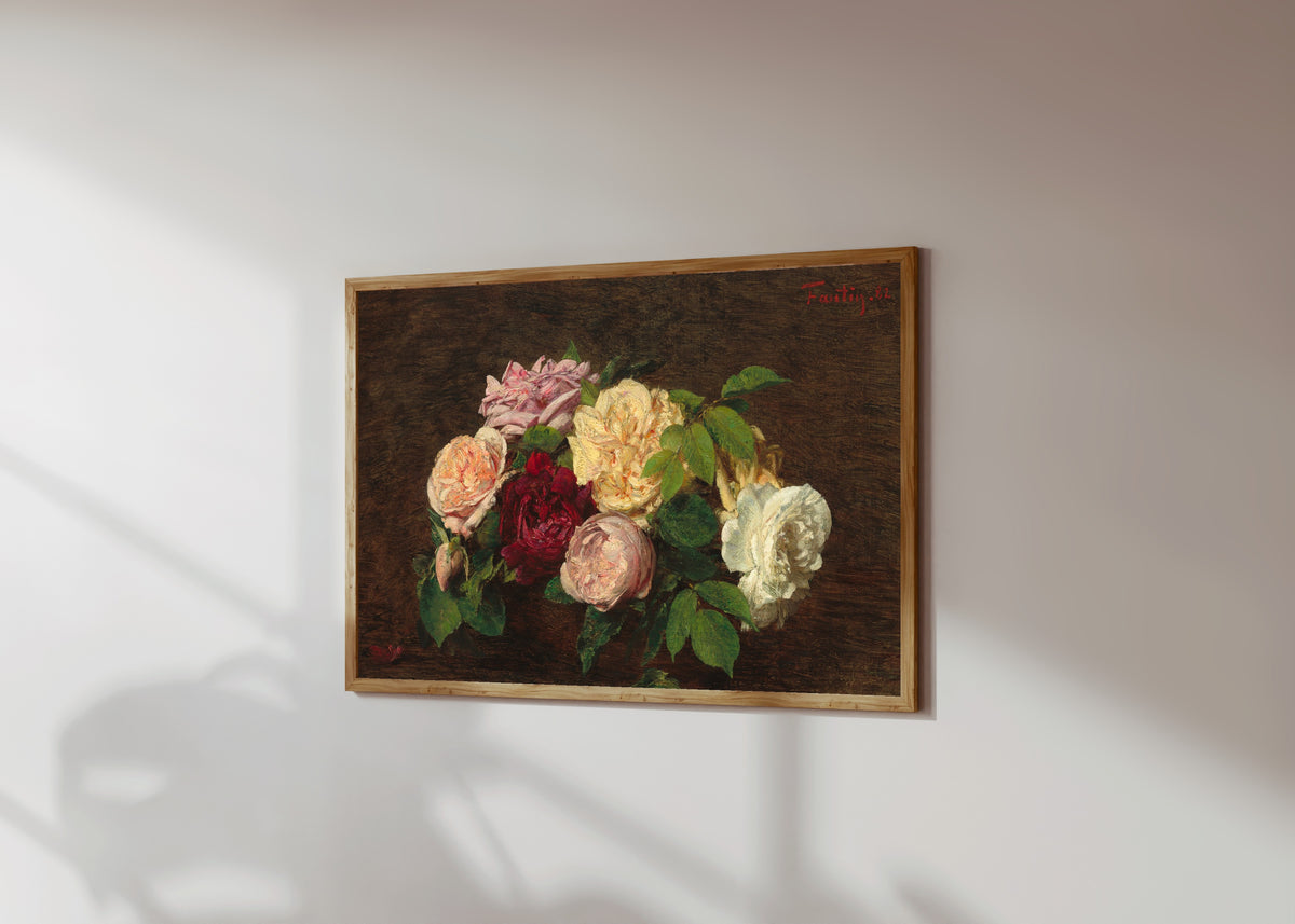 Framed art print of Roses de Nice on a Table by Henri Fantin-Latour, in a light wood frame on a sunlit white wall, seen at a slight angle