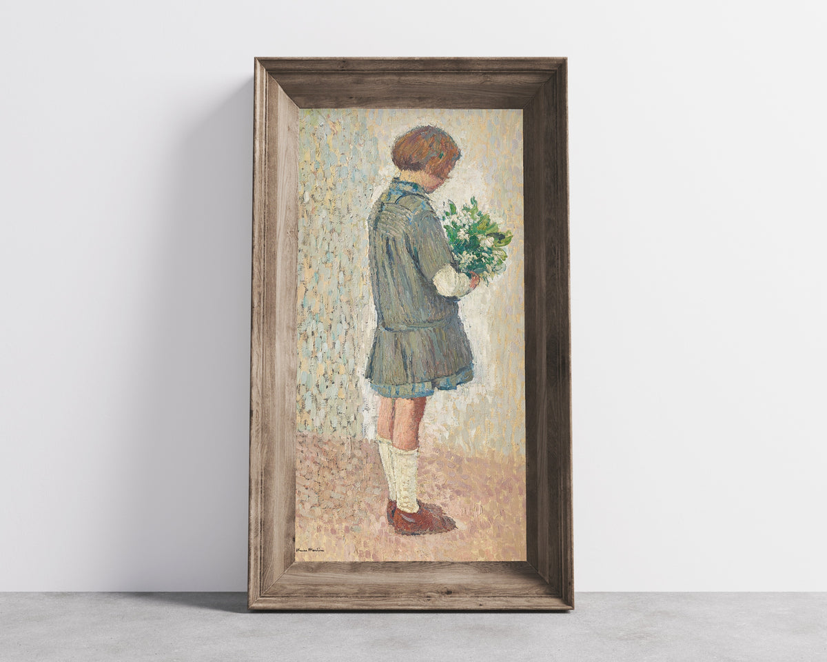 Framed art print of Fillette en tablier d’écolière tenant un bouquet by Henri Martin, in a wide wooden frame leaning against a concrete wall