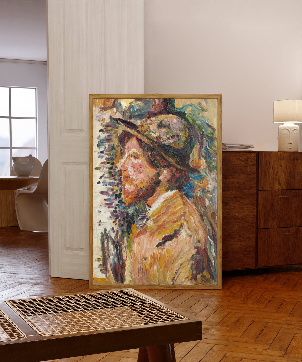 Framed art print of Homme en buste de profil by Henri Martin, in a light wood frame leaning in a warm room with a parquet floor