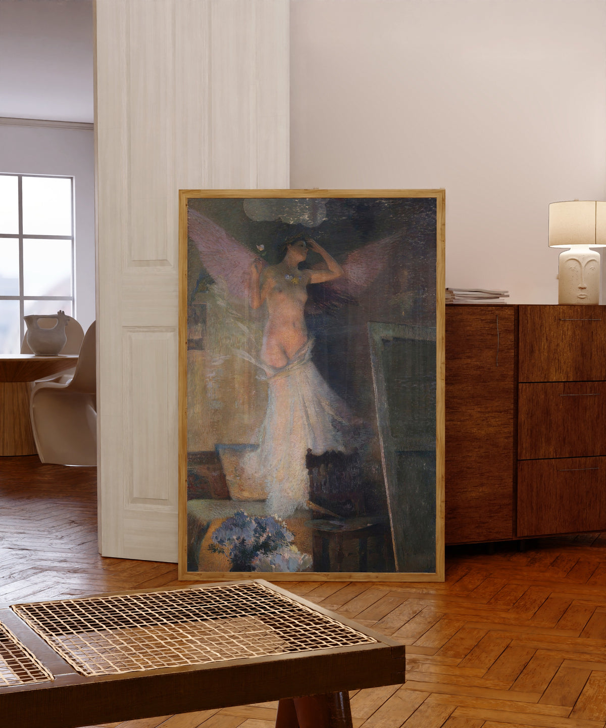 Framed art print of La Muse du peintre by Henri Martin, in a light wood frame leaning in a warm room with a parquet floor