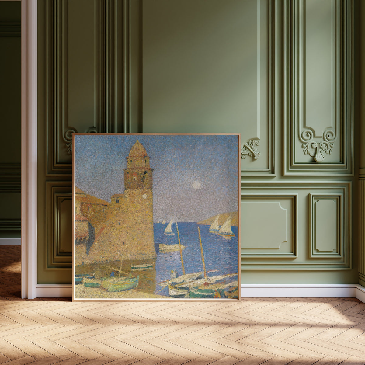 Framed art print of La Tour de Collioure, lever de lune by Henri Martin, leaning against olive-green panelling on a herringbone floor