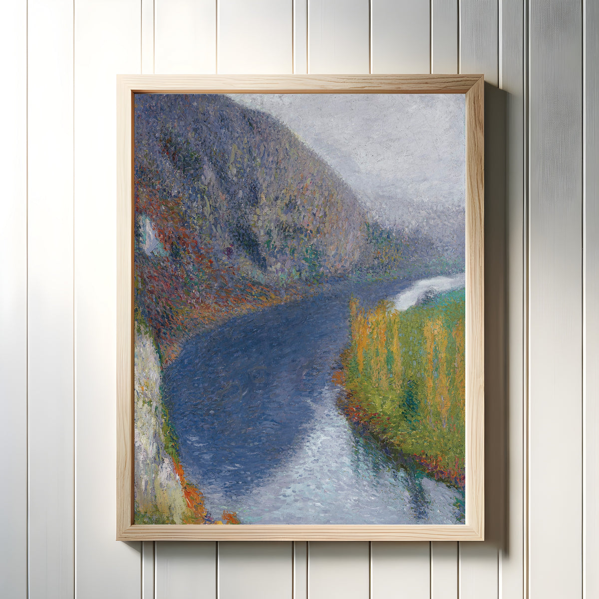 Framed art print of Le Lot au pied des falaises de St-Cirq-Lapopie (Pale Grey Sky) by Henri Martin, in a light wood frame on a white panelled wall