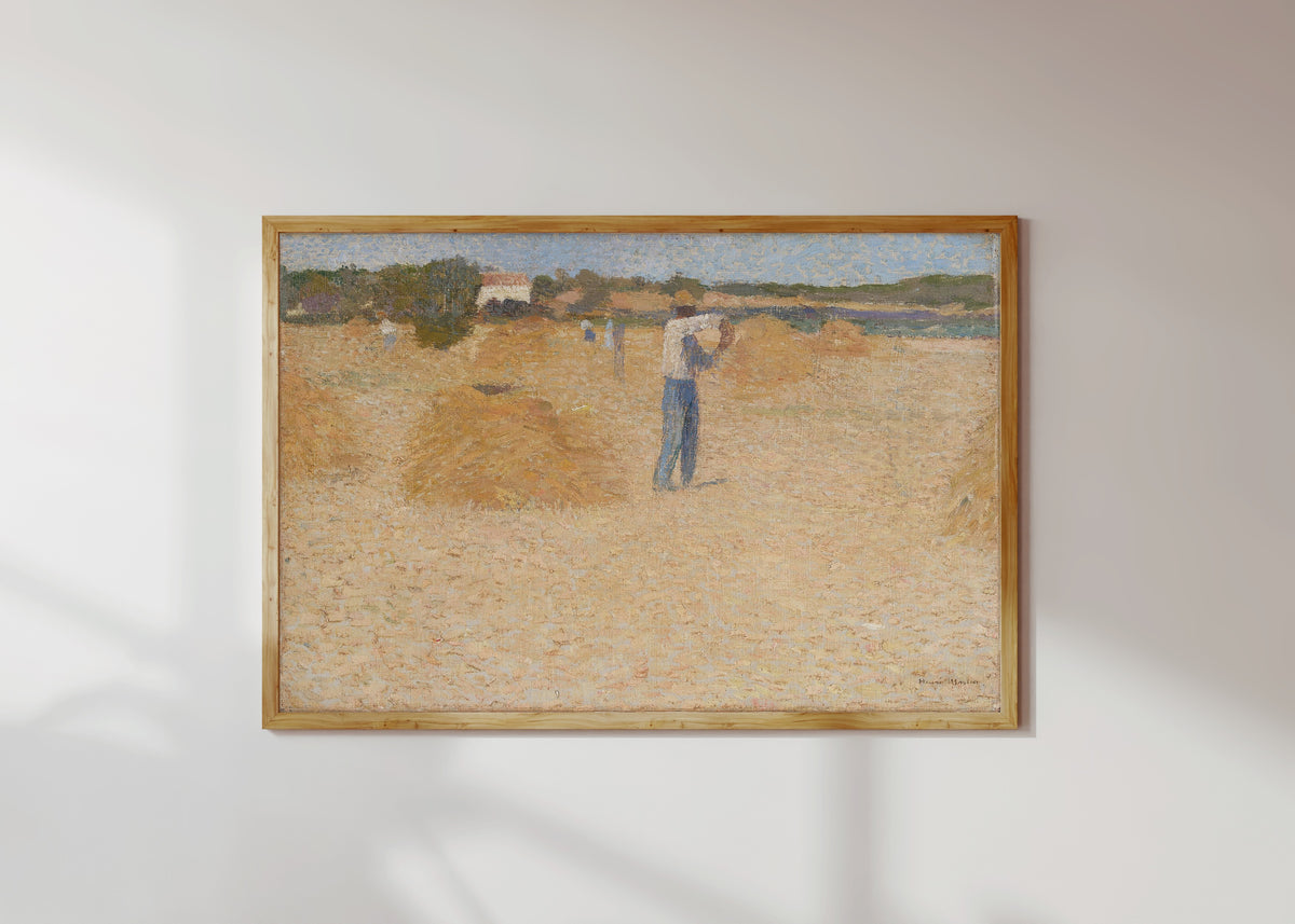 Framed art print of Les Moissons de blé by Henri Martin, in a light wood frame on a sunlit white wall