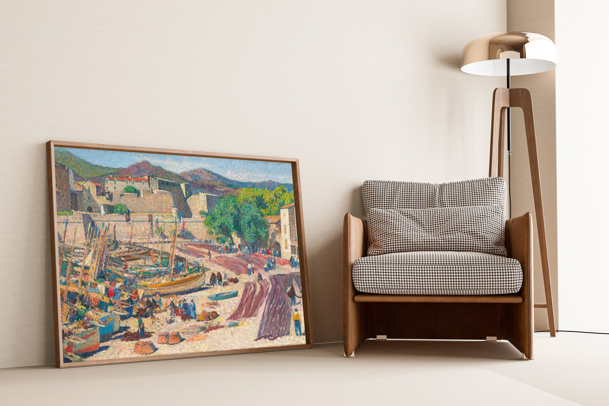 Framed art print of Port de Collioure le 14 juillet, séchage des filets sur la grève by Henri Martin, leaning against a wall beside an armchair and a floor lamp
