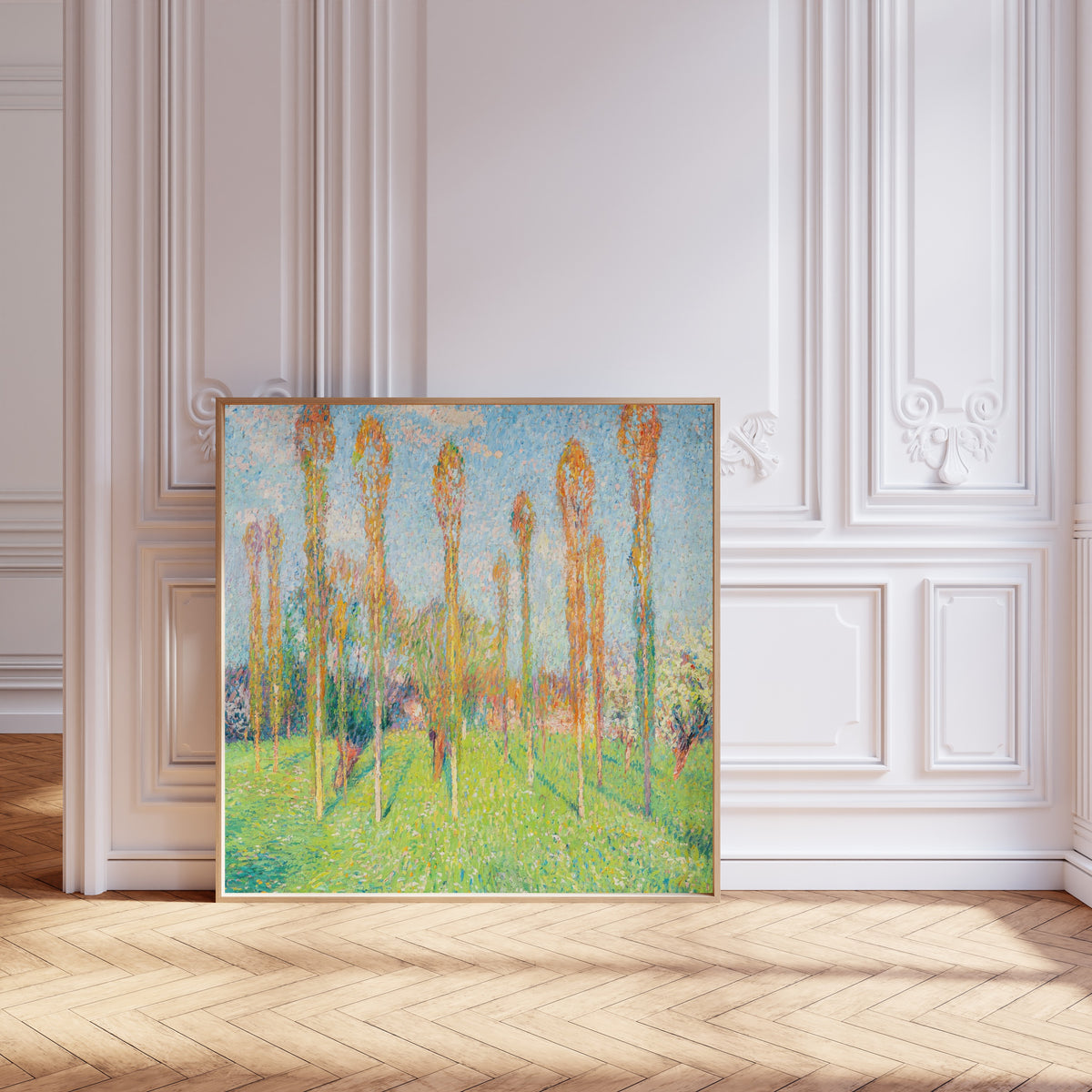 Framed art print of Prairie ensoleillée aux peupliers by Henri Martin, leaning against pale pink panelling on a herringbone floor