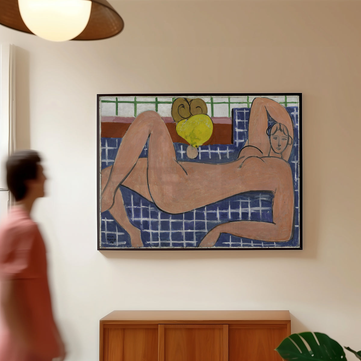 Framed art print of Large Reclining Nude (The Pink Nude) by Henri Matisse, in a slim black frame on a warm wall in a sunlit room