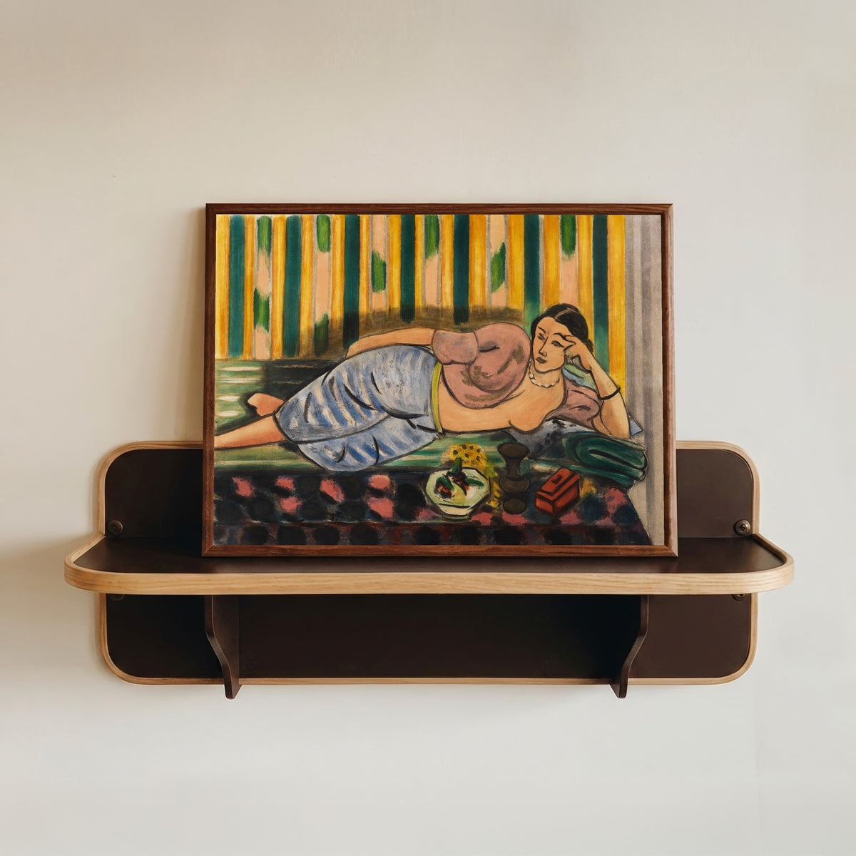 Framed art print of Odalisque with a Red Casket by Henri Matisse, in a dark wood frame resting on a wall shelf