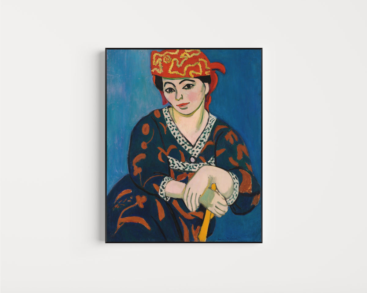 Framed art print of Red Madras Headdress (Le Madras rouge) by Henri Matisse, in a slim black frame on a plain white wall