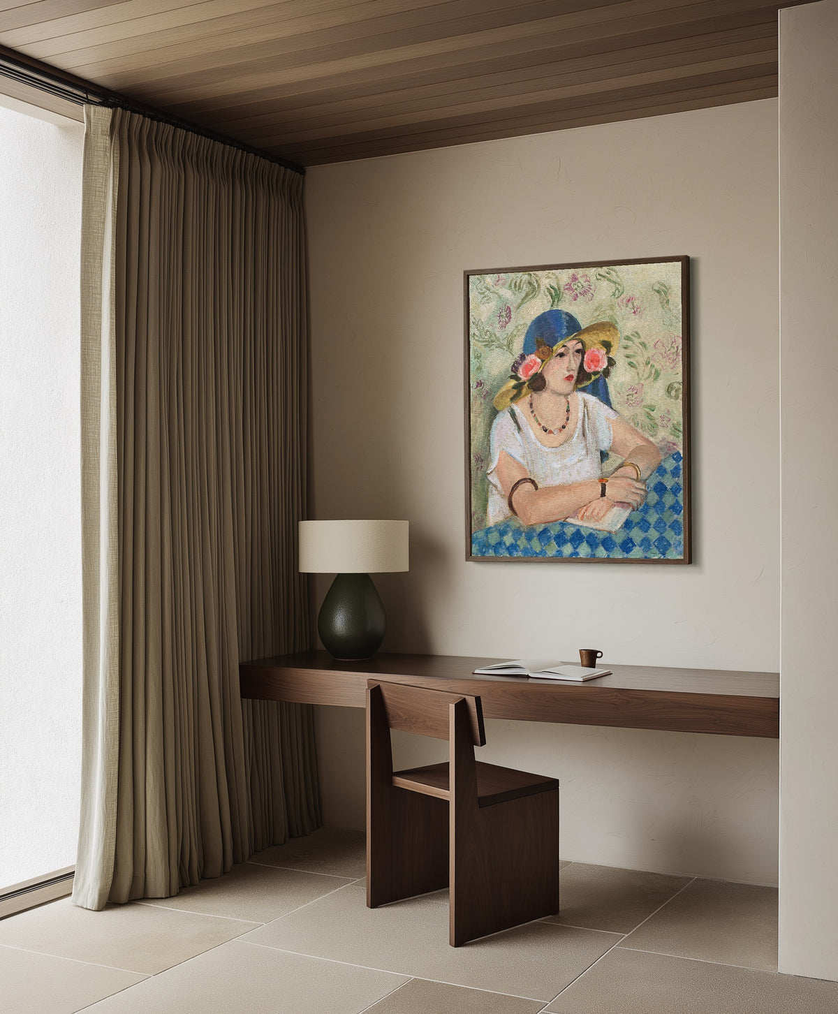 Framed art print of Woman with a Flowered Hat by Henri Matisse, in a dark wood frame on a plaster wall above a walnut desk