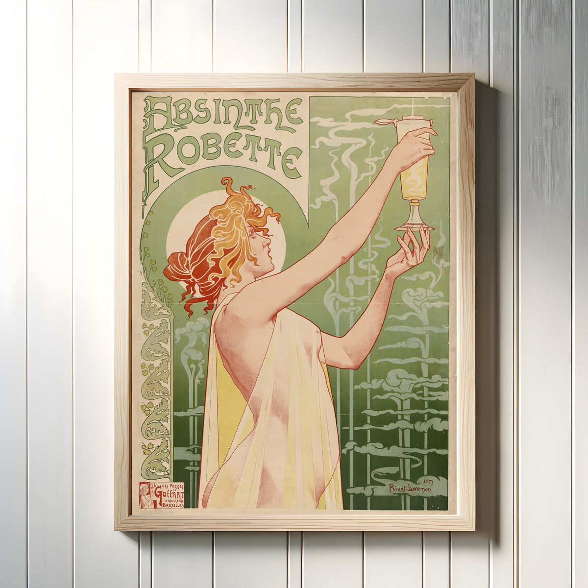 Framed art print of Absinthe Robette by Henri Privat-Livemont, in a light wood frame on a white panelled wall