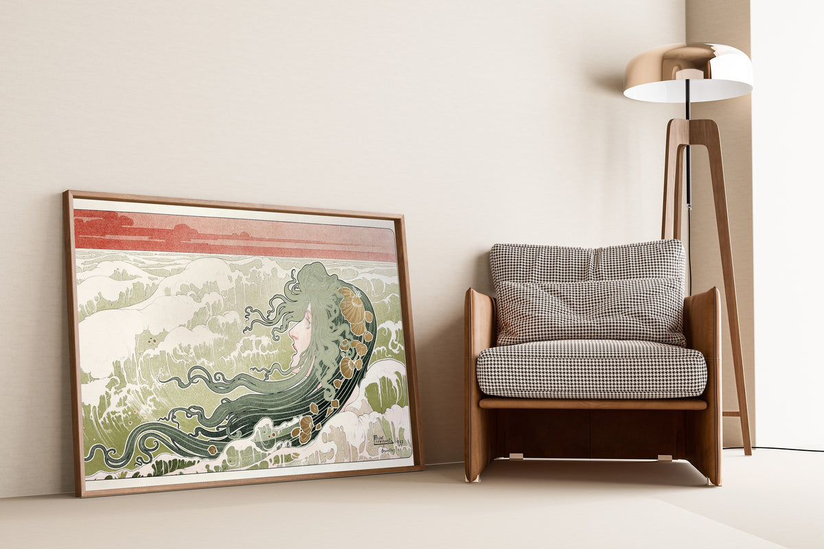 Framed art print of La Vague (The Wave) by Henri Privat-Livemont, leaning against a wall beside an armchair and a floor lamp