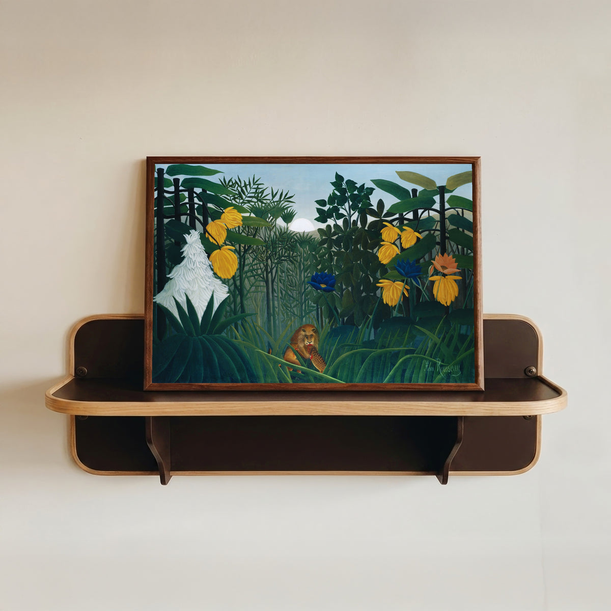Framed art print of The Repast of the Lion by Henri Rousseau, in a dark wood frame resting on a wall shelf