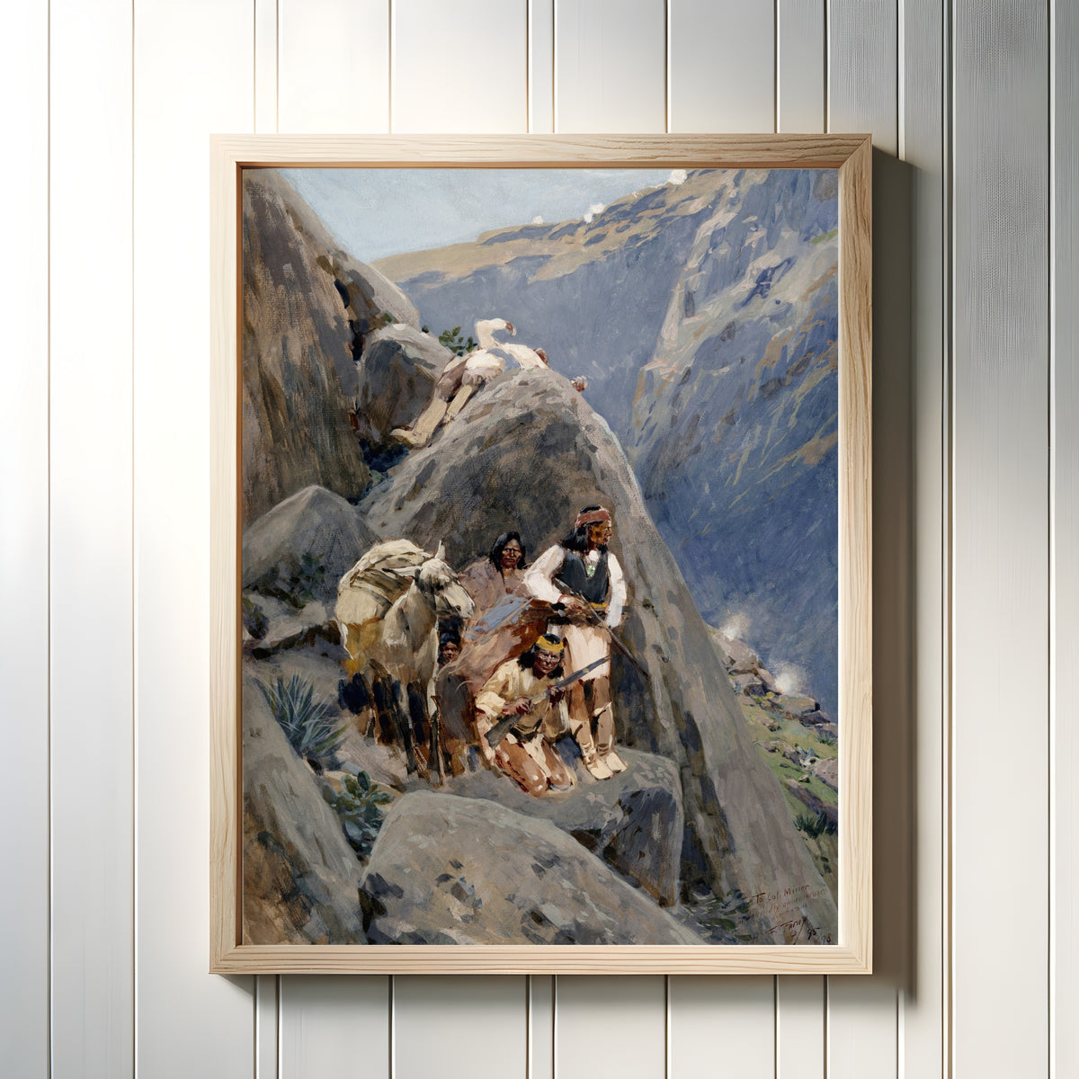 Framed art print of Apache Indians in the Mountains by Henry Farny, in a light wood frame on a white panelled wall
