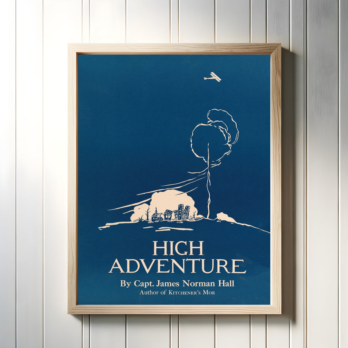 Framed art print of High Adventure by Edward Penfield, in a light wood frame on a white panelled wall