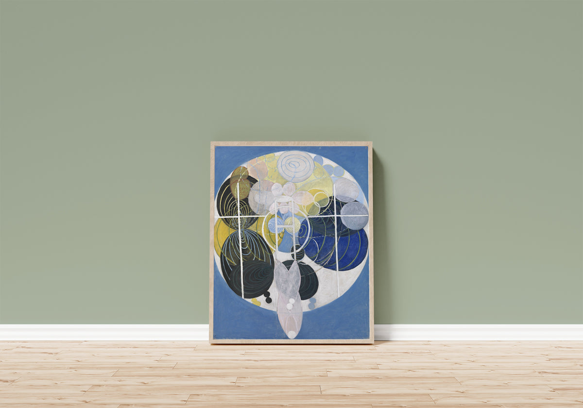 Framed art print of The Large Figure Paintings, No. 5, Group 3 by Hilma af Klint, in a light wood frame leaning on a sage green wall above a wooden floor