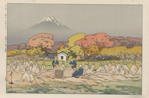 Autumn by Hiroshi Yoshida — Fuji over autumn trees and a harvest field of conical stacks
