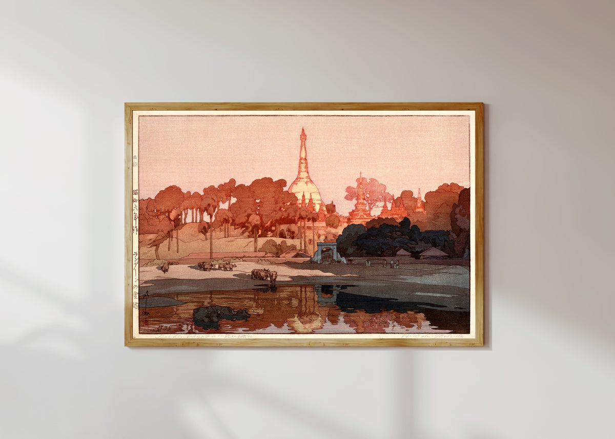 Framed art print of Golden Pagoda in Rangoon by Hiroshi Yoshida, in a light wood frame on a sunlit white wall