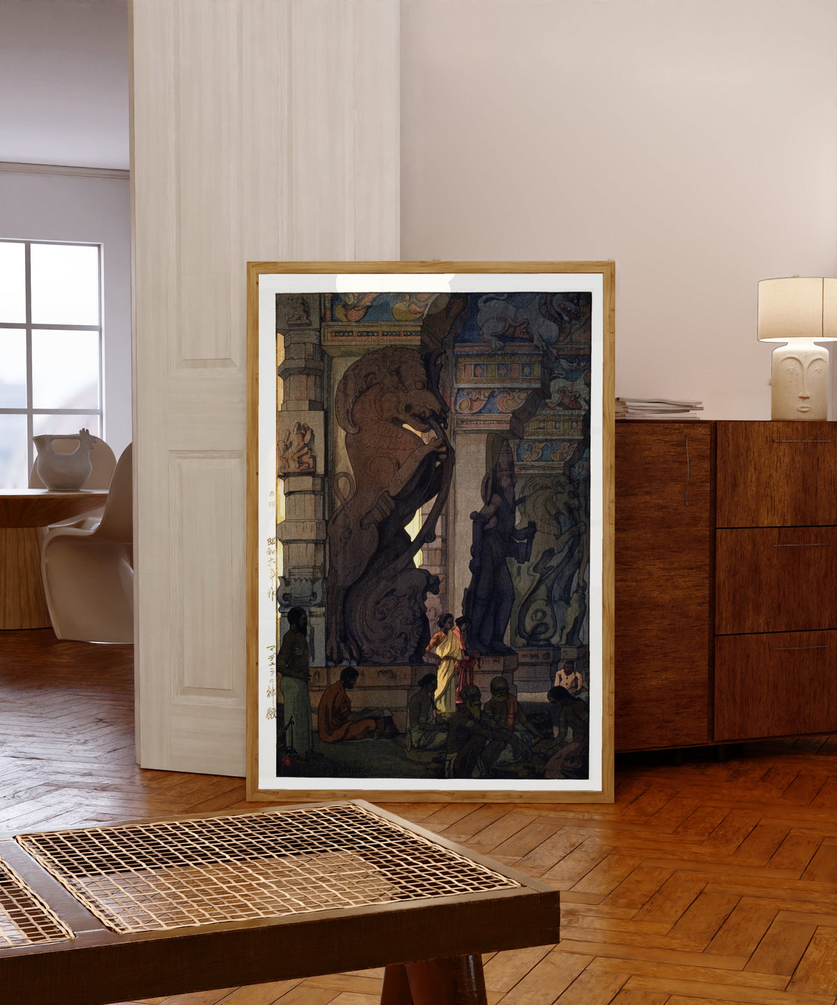 Framed art print of Great Temple at Madurai, Tamil Nadu, India by Hiroshi Yoshida, in a light wood frame leaning in a warm room with a parquet floor