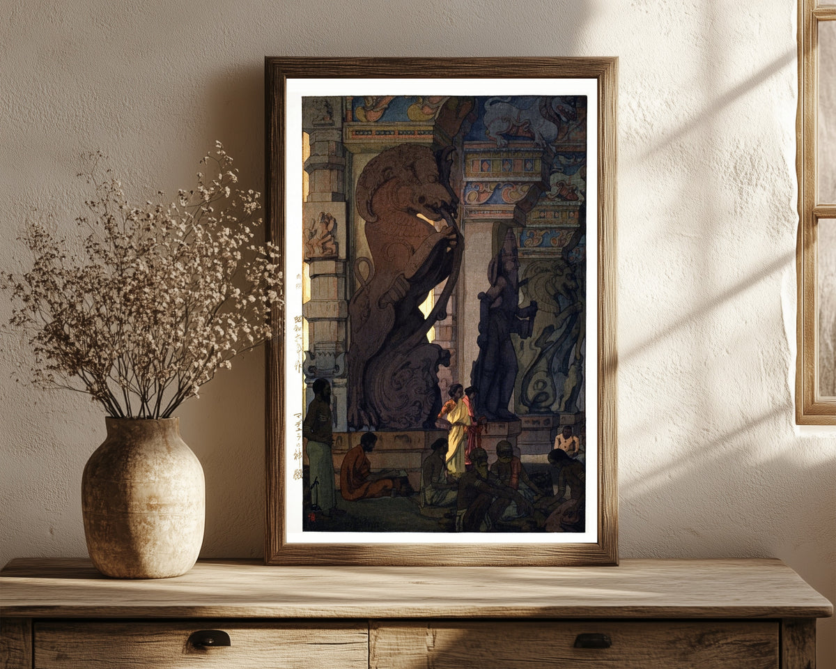 Framed art print of Great Temple at Madurai, Tamil Nadu, India by Hiroshi Yoshida, in a dark wood frame leaning on a rustic console beside dried flowers