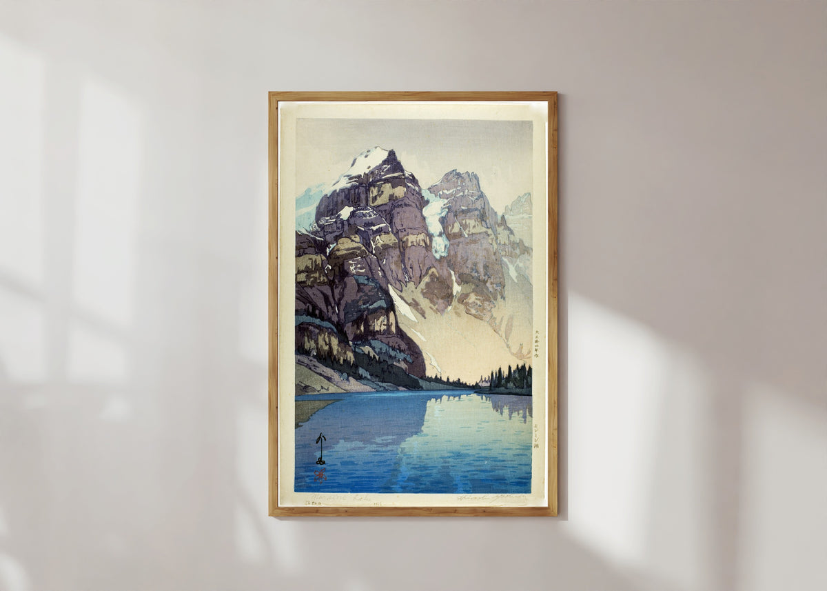 Framed art print of Moraine Lake by Hiroshi Yoshida, in a light wood frame on a sunlit white wall