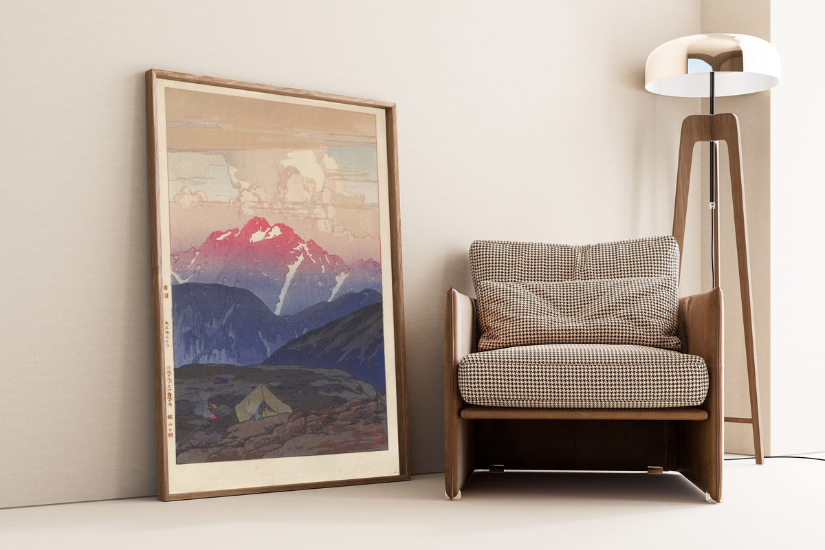 Framed art print of Morning at Mount Tsurugi by Hiroshi Yoshida, leaning against a wall beside an armchair and a floor lamp