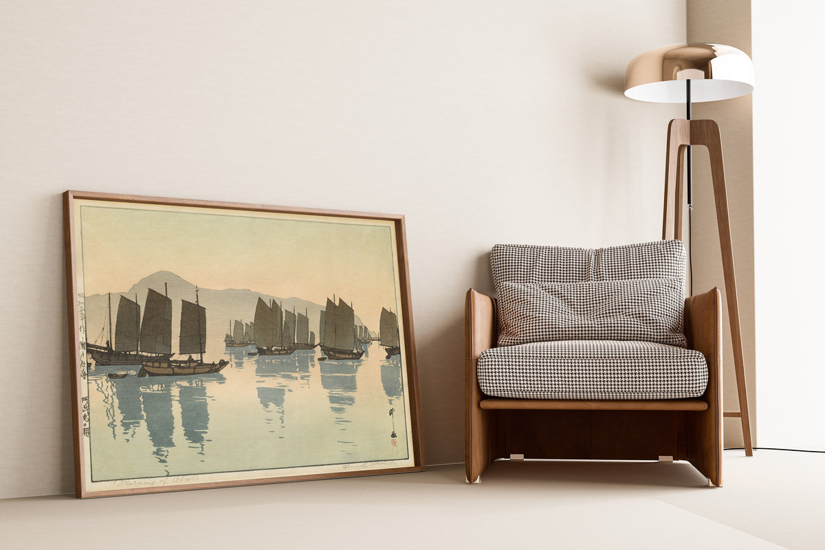 Framed art print of Morning of Abuto from Inland Sea, Second Series by Hiroshi Yoshida, leaning against a wall beside an armchair and a floor lamp