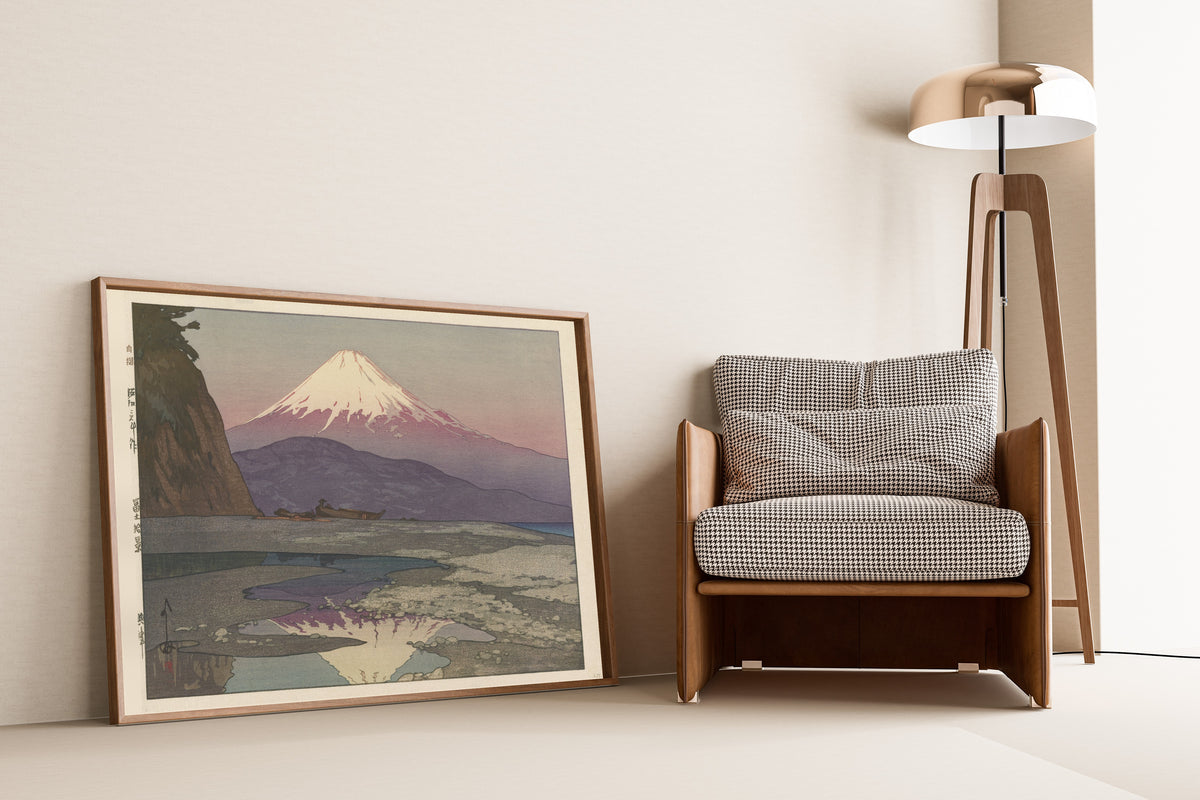 Framed art print of Okitsu by Hiroshi Yoshida, leaning against a wall beside an armchair and a floor lamp