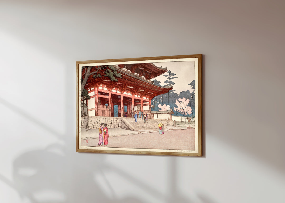 Framed art print of Omuro by Hiroshi Yoshida, in a light wood frame on a sunlit white wall, seen at a slight angle