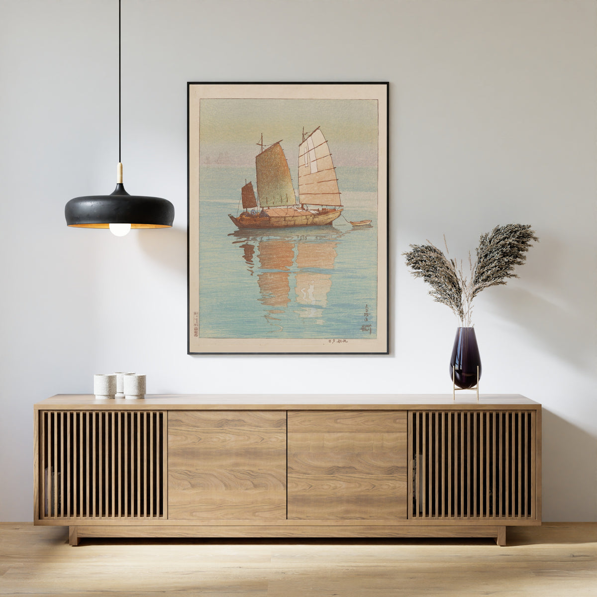 Framed art print of Sailing Boats, Evening Glow by Hiroshi Yoshida, above a slatted wood sideboard