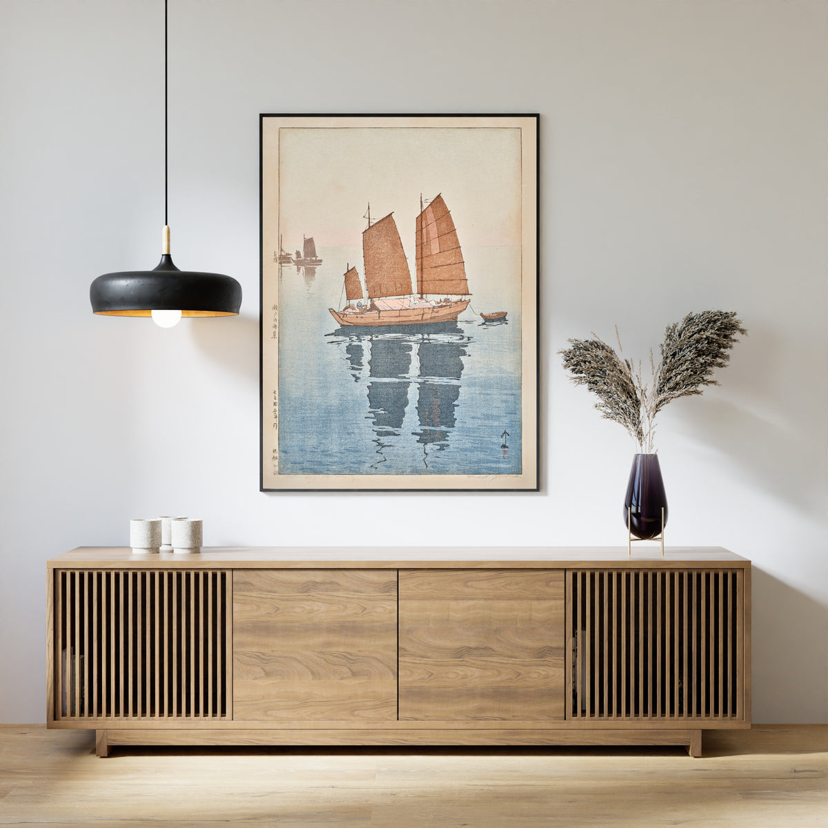 Framed art print of Sailing Boats, Forenoon by Hiroshi Yoshida, above a slatted wood sideboard