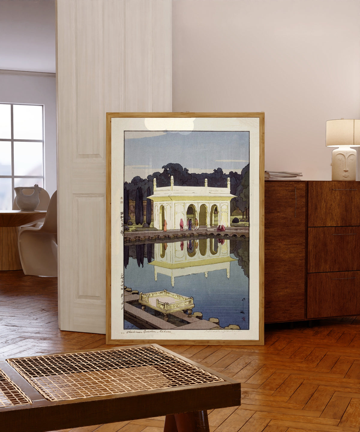Framed art print of Shalimar Gardens, Lahore by Hiroshi Yoshida, in a light wood frame leaning in a warm room with a parquet floor
