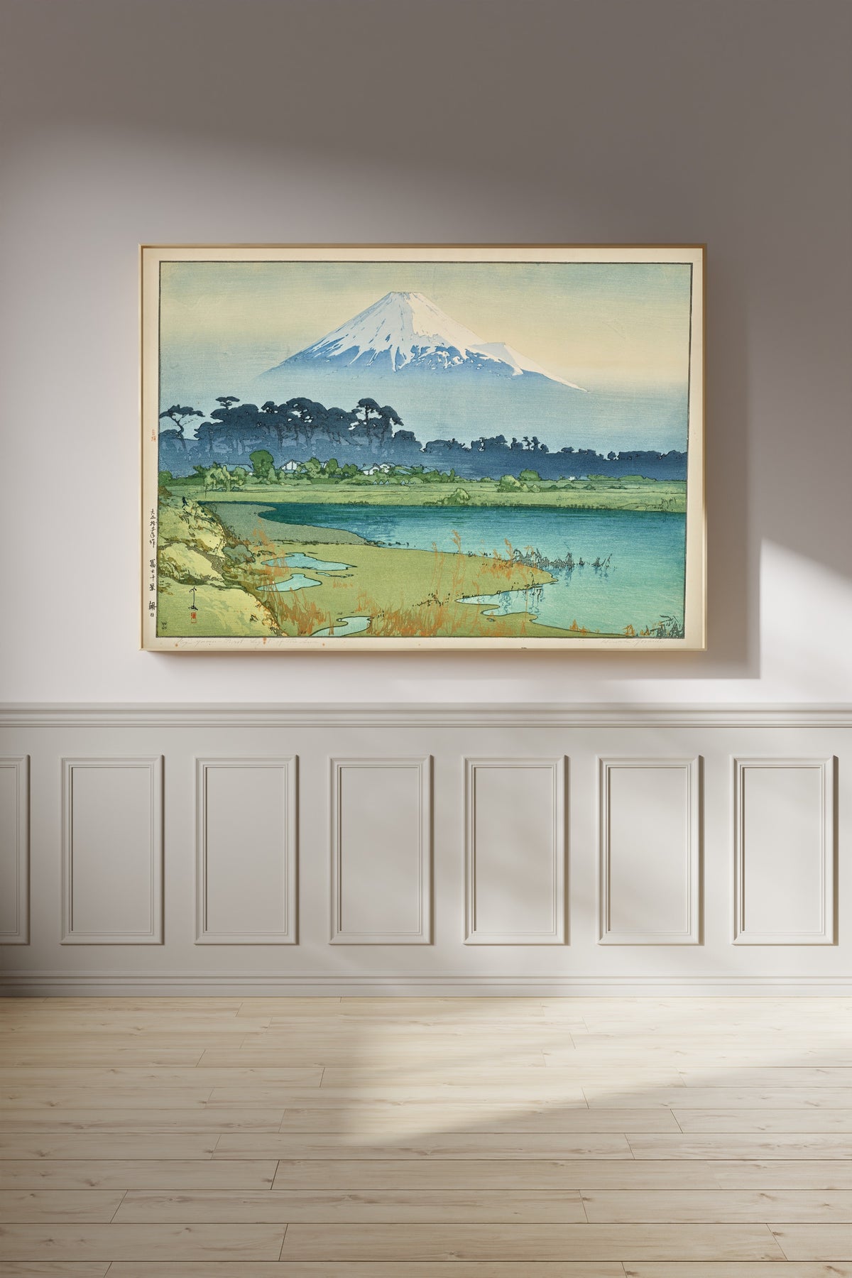 Framed art print of Sunrise by Hiroshi Yoshida, on a panelled wall in afternoon light
