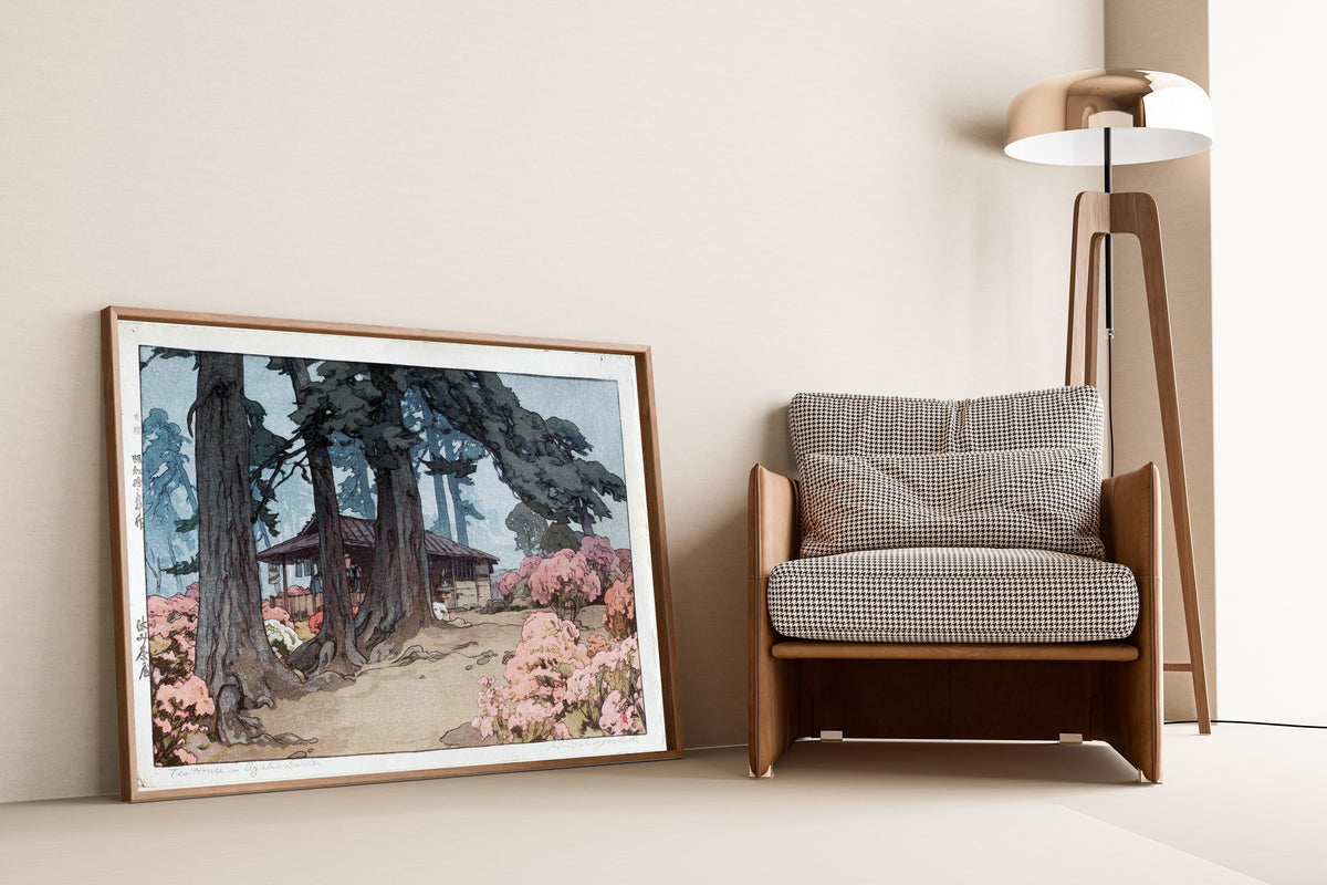 Framed art print of Tea House in Azalea Garden by Hiroshi Yoshida, leaning against a wall beside an armchair and a floor lamp