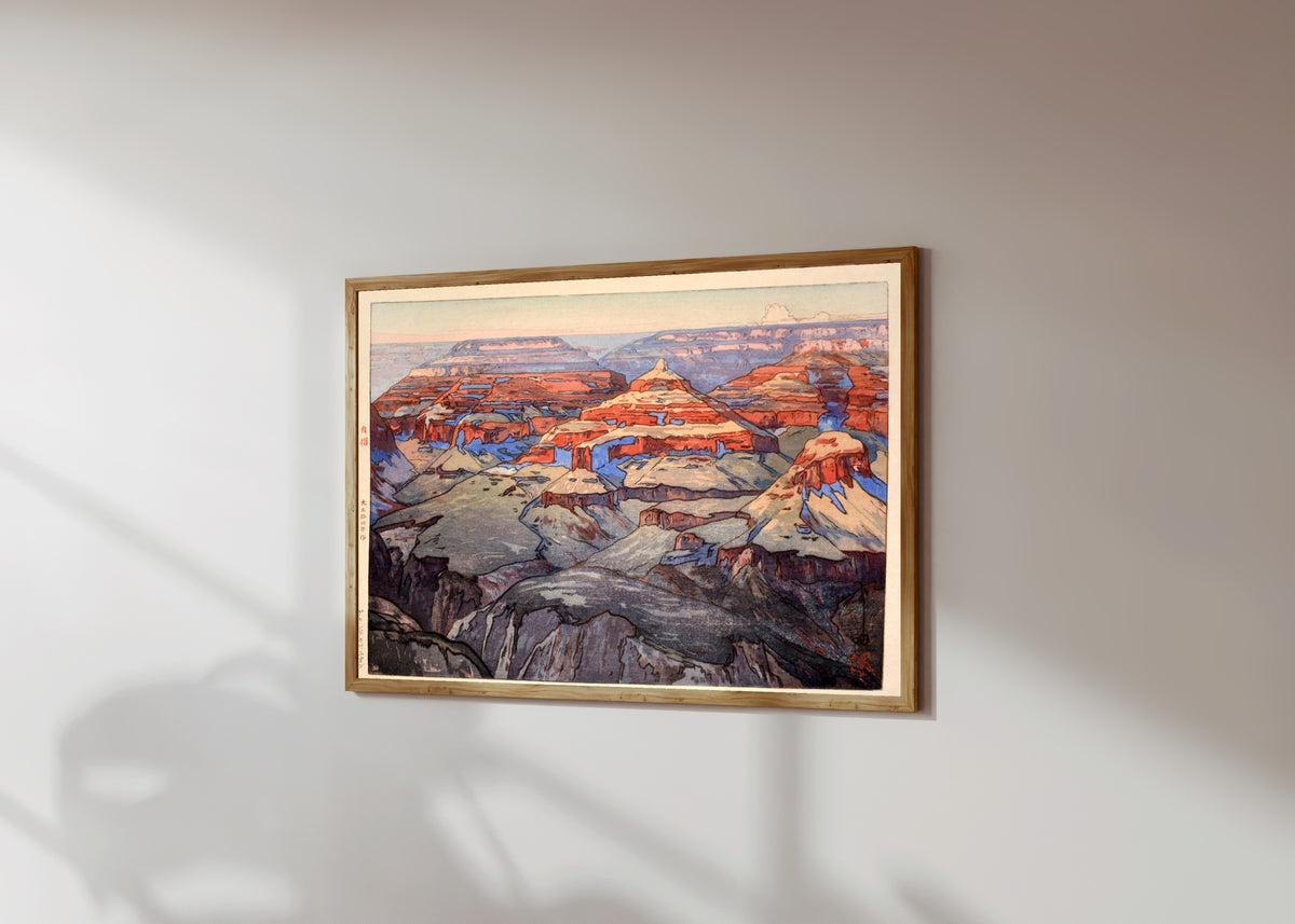 Framed art print of The Grand Canyon by Hiroshi Yoshida, in a light wood frame on a sunlit white wall, seen at a slight angle