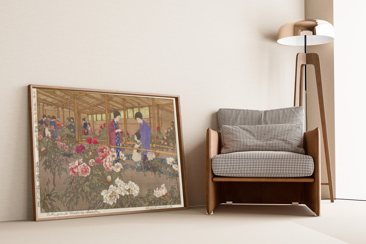 Framed art print of The Tokugawa Peony Garden at Ochiai by Hiroshi Yoshida, leaning against a wall beside an armchair and a floor lamp
