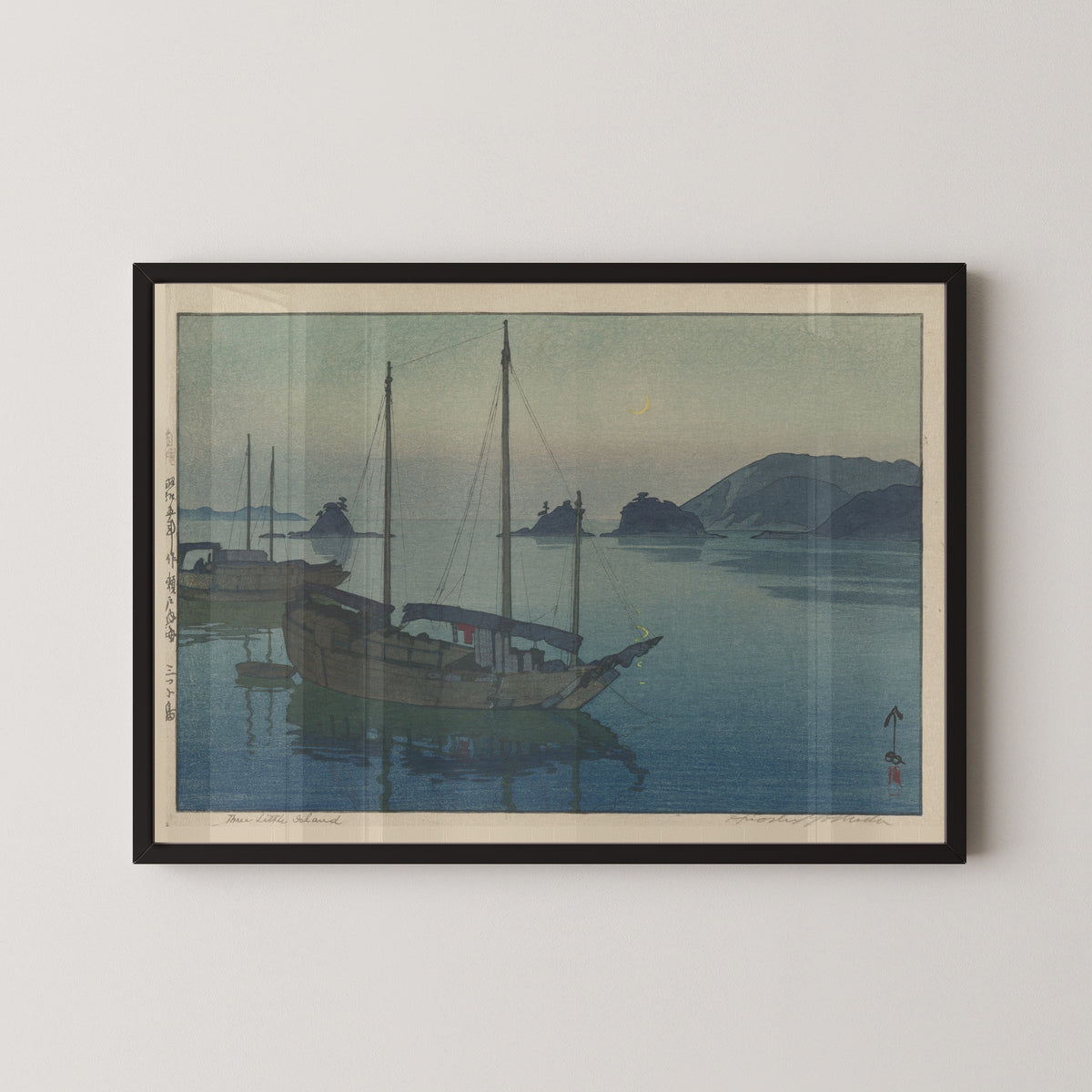 Framed art print of Three Little Islands by Hiroshi Yoshida, in a black frame on a pale wall