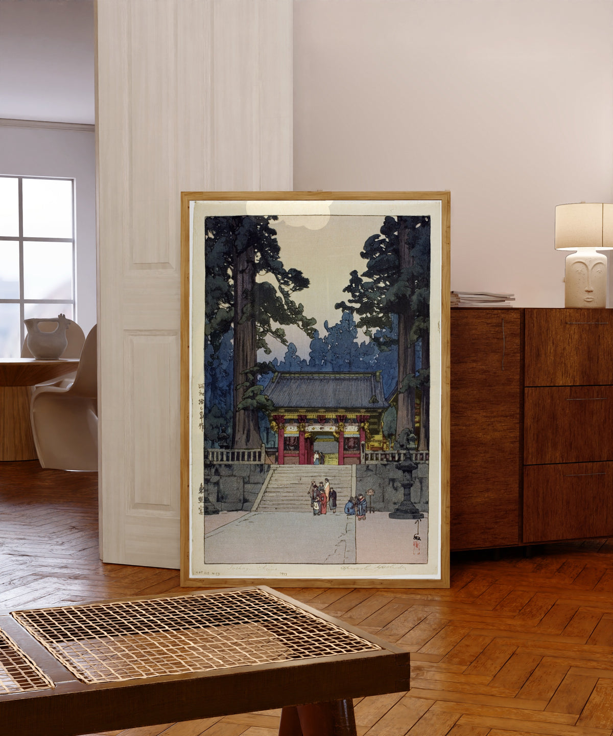 Framed art print of Toshogu Shrine by Hiroshi Yoshida, in a light wood frame leaning in a warm room with a parquet floor