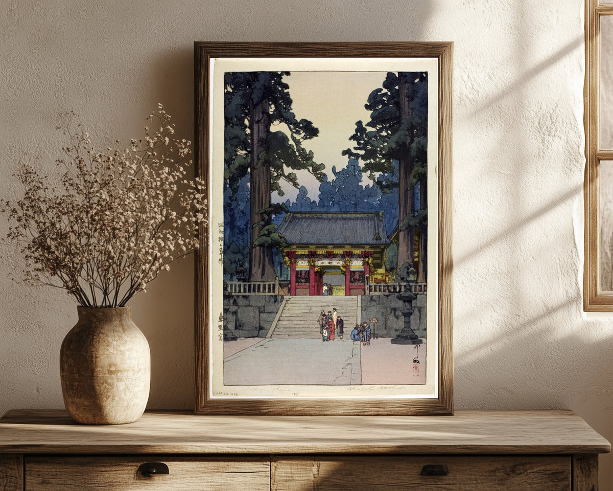 Framed art print of Toshogu Shrine by Hiroshi Yoshida, in a dark wood frame leaning on a rustic console beside dried flowers