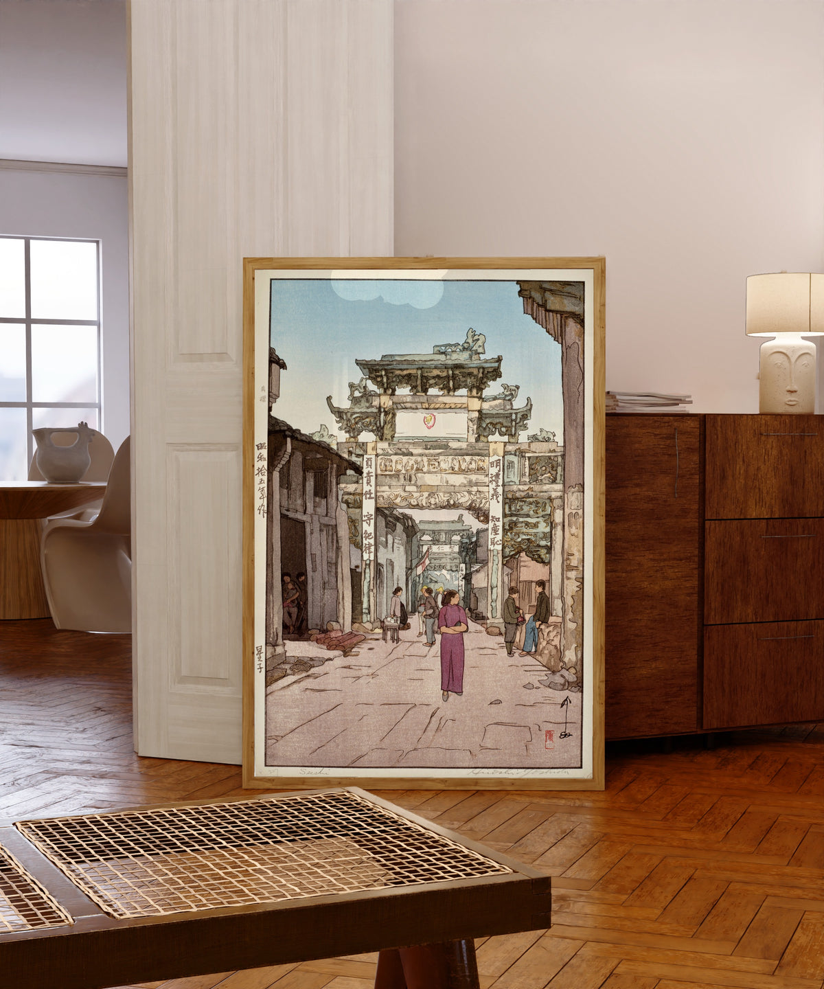 Framed art print of Xingzi by Hiroshi Yoshida, in a light wood frame leaning in a warm room with a parquet floor