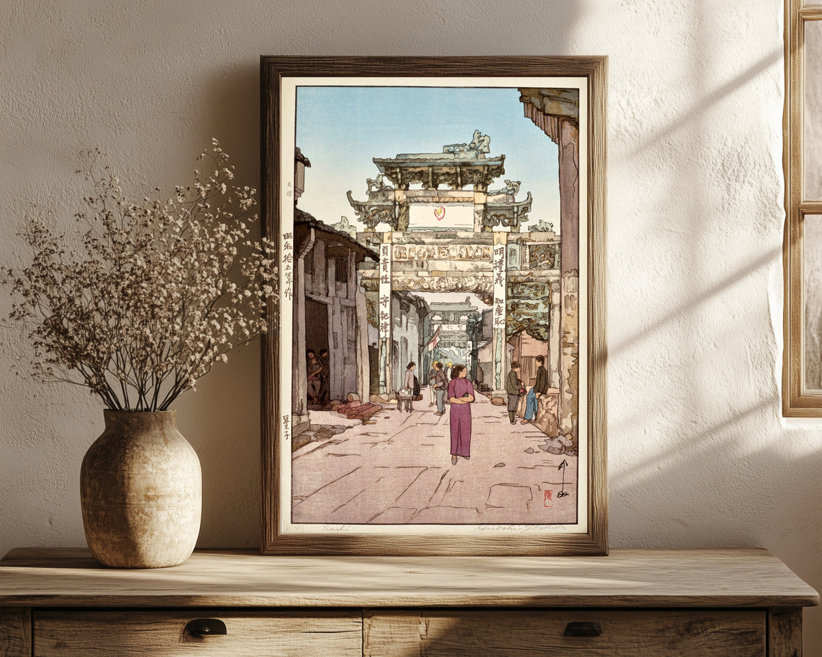 Framed art print of Xingzi by Hiroshi Yoshida, in a dark wood frame leaning on a rustic console beside dried flowers