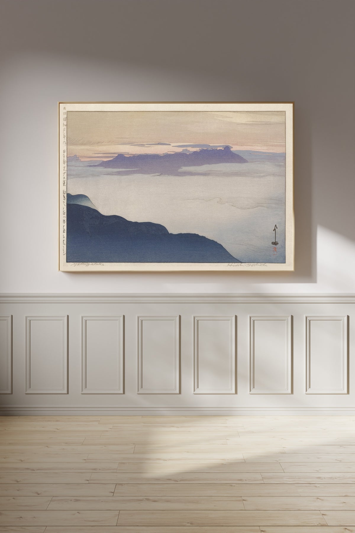 Framed art print of Yatsugatake after Rain by Hiroshi Yoshida, on a panelled wall in afternoon light
