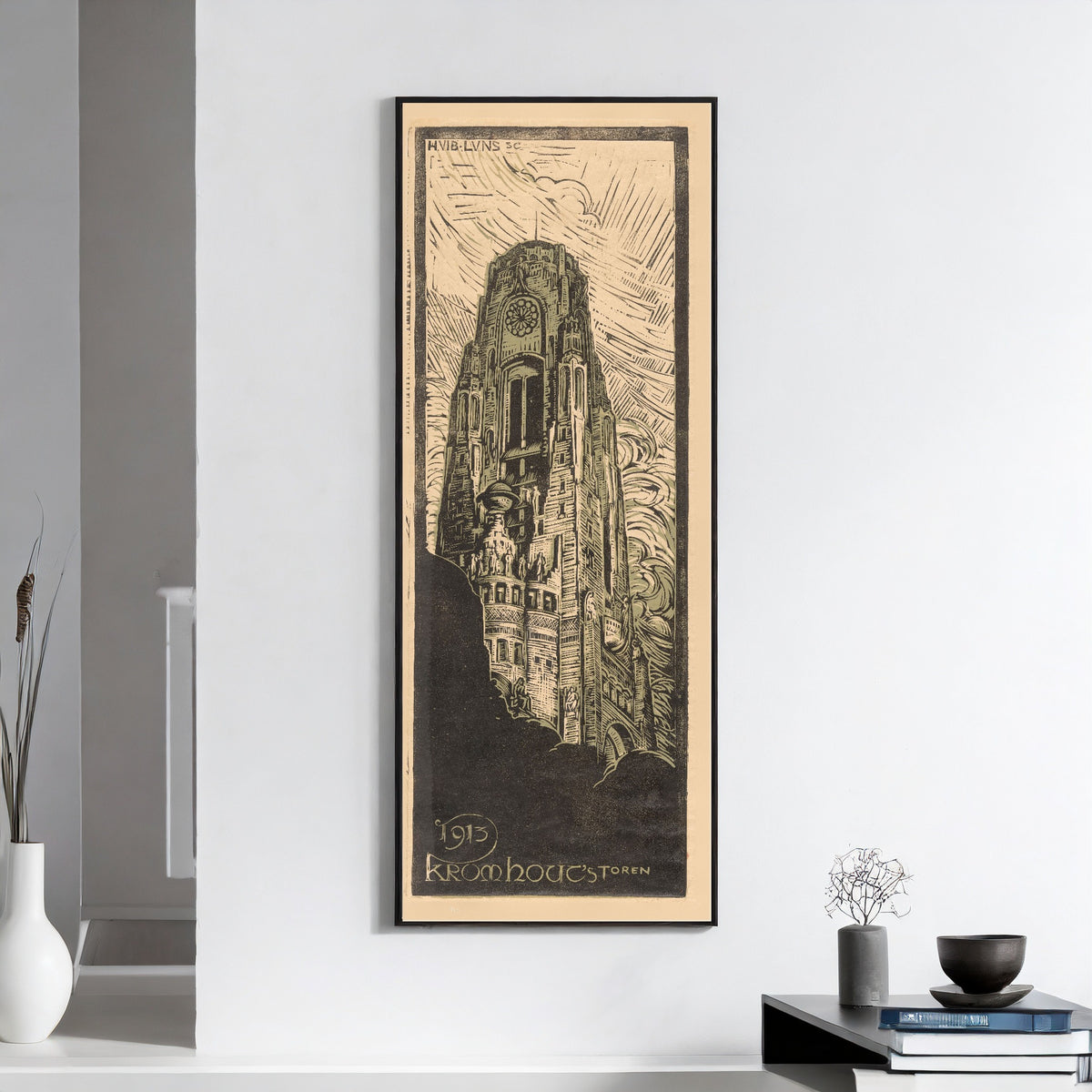 Raadhuistoren [Town hall tower] by Huib Luns — framed on a white wall above books and a bowl