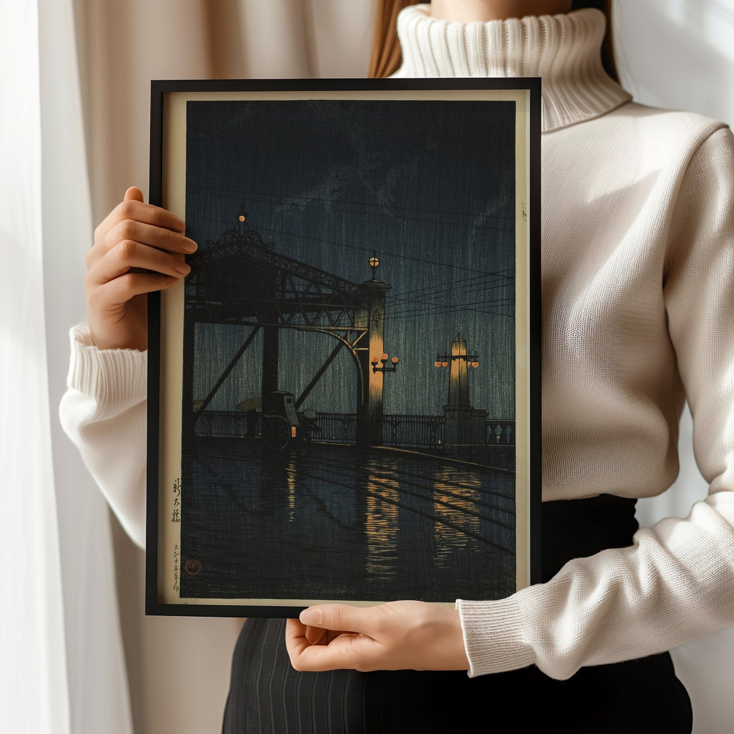 Person holding a framed print of Kawase Hasui's Shin Ohashi Bridge at Night, highlighting vintage Japanese woodblock art.