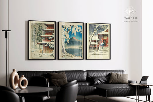 Set of 3 framed Kawase Hasui snow theme art prints in modern living room with black leather sofa.