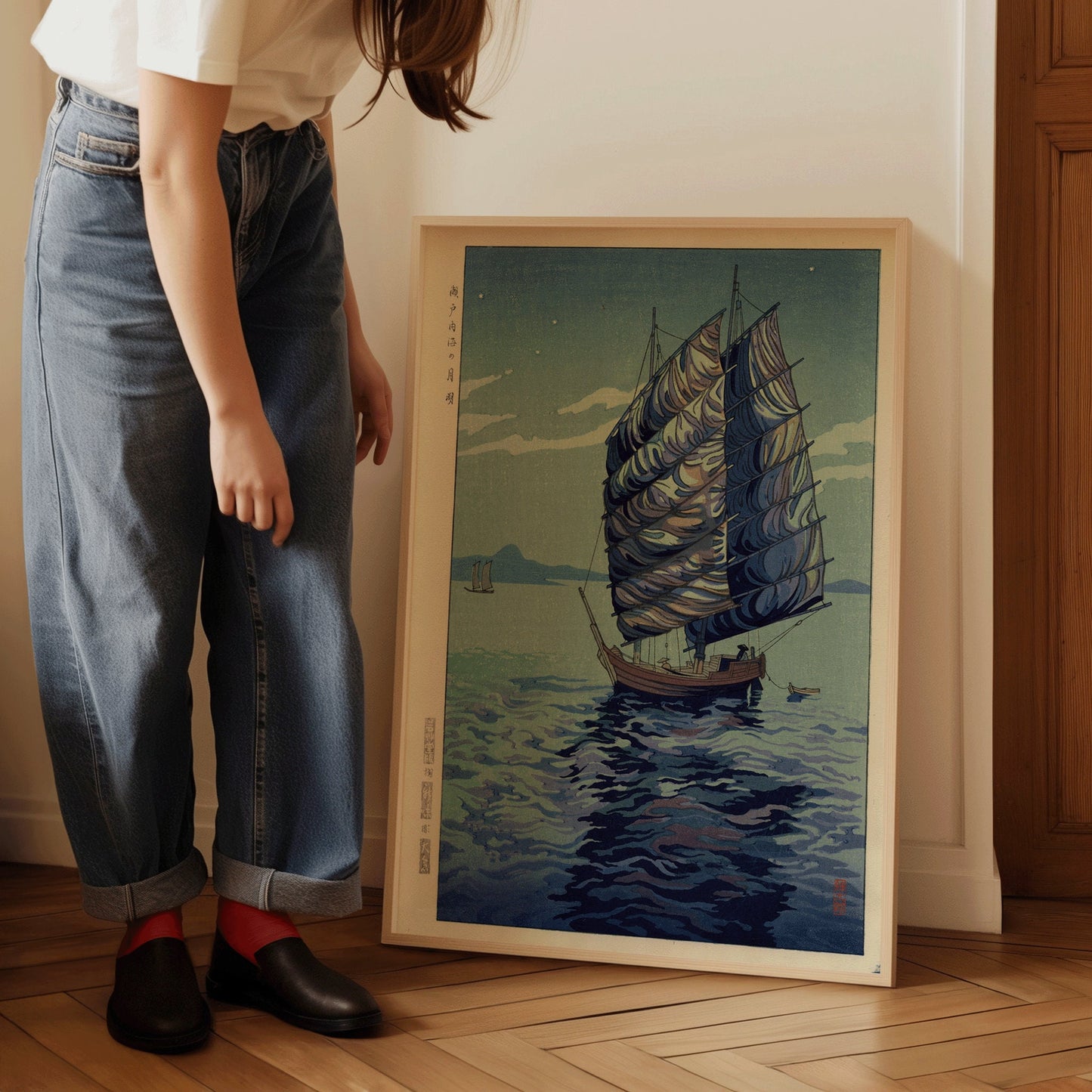 Vintage Japanese woodblock print of a sailboat on the sea, titled "Moonlight Over the Inland Sea, Seto," displayed in a wooden frame.